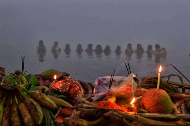 Devotees offering prayers at the river during Chhath Puja